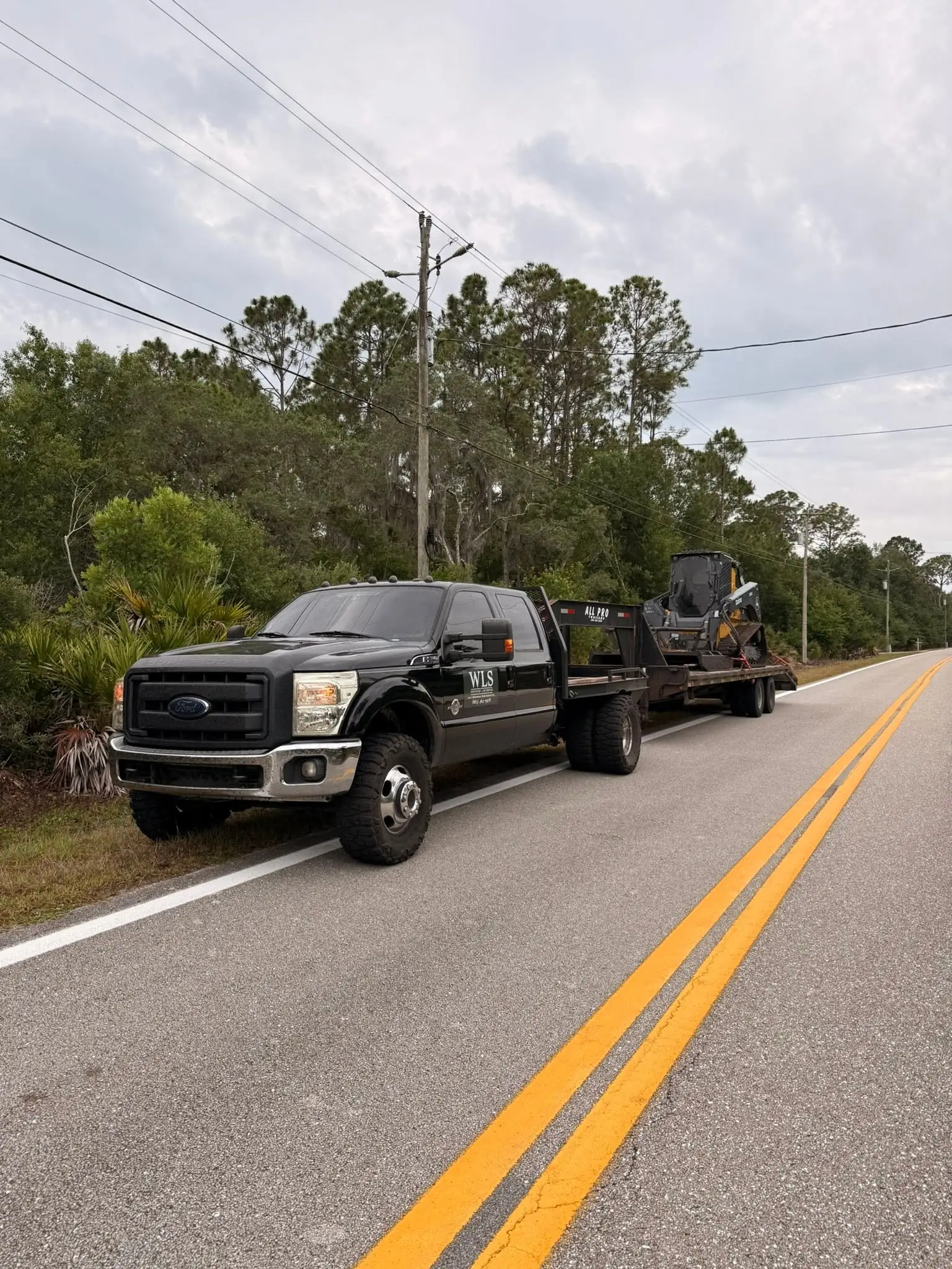 WLS truck hauling the skid steer